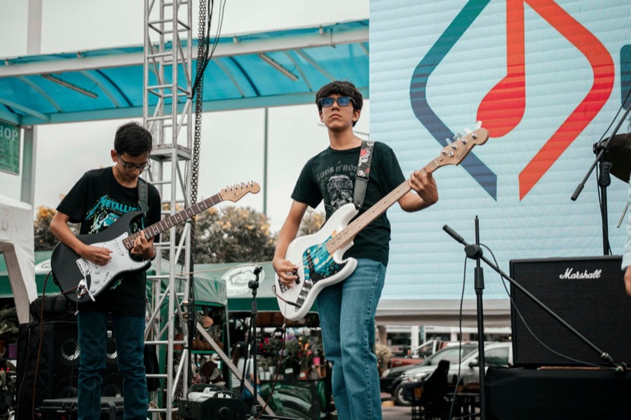 Estudiantes de Edumymusic en concierto sobre escenario con reflectores
